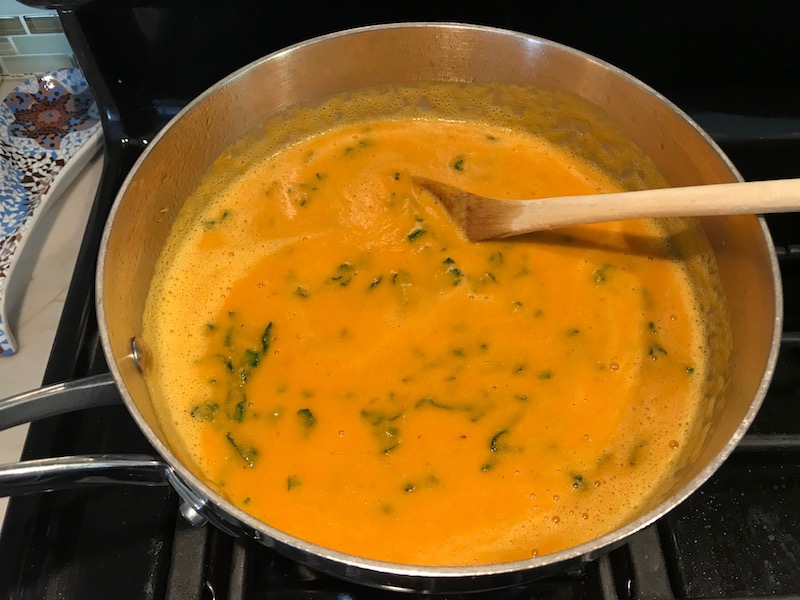 Creamy Carrot Soup with Kale in a pot on stove. With Roasted Chickpeas and Thyme is a creamy, textured, easy-to-make soup! It's great as a starter, but hearty enough to be a meal with Kale and Chickpeas. Not only does this soup taste delicious, it's also incredibly healthy with vitamins, nutrients, fiber, and protein!