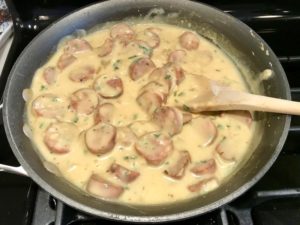 Cheesy Chicken Sausage in skillet for Sausage & Broccoli Rice Casserole.