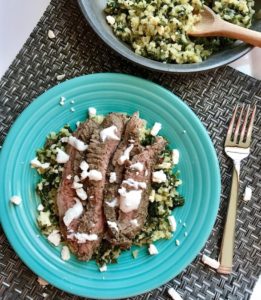 Mediterranean Flank Steak with Kale & Feta Cauliflower Rice is a delicious Mediterranean-inspired recipe with a flavorful garlic-oregano-rubbed flank steak on top of delicious cauliflower “rice”.  To finish it off, a cool and bright Lemon & Garlic Yogurt Sauce. 