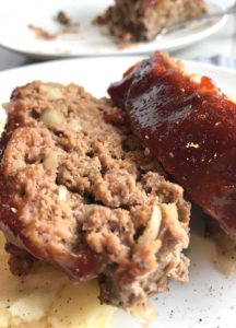 Close up picture of sliced meatloaf with ketchup on top. This 5-Ingredient Easy Meatloaf recipe may be short on ingredients, but it is loaded with flavor. The lack of breadcrumbs means you don't have them soaking up the juices, so the meat stays moist - and it's gluten free too! Parmesan cheese, onion, egg, ketchup, salt, and pepper are all that go into this yummy loaf of goodness!