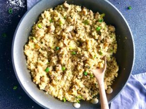 This is a Creamy Parmesan Quinoa Mushroom Risotto in a pan on the stove is a recipe with garlic, parmesan, and mushrooms. I swapped the heavy cream for low fat milk and you will not miss any of the flavor, I promise! The quinoa soaks up the broth just as rice does so you make it the same way until it becomes creamy deliciousness.