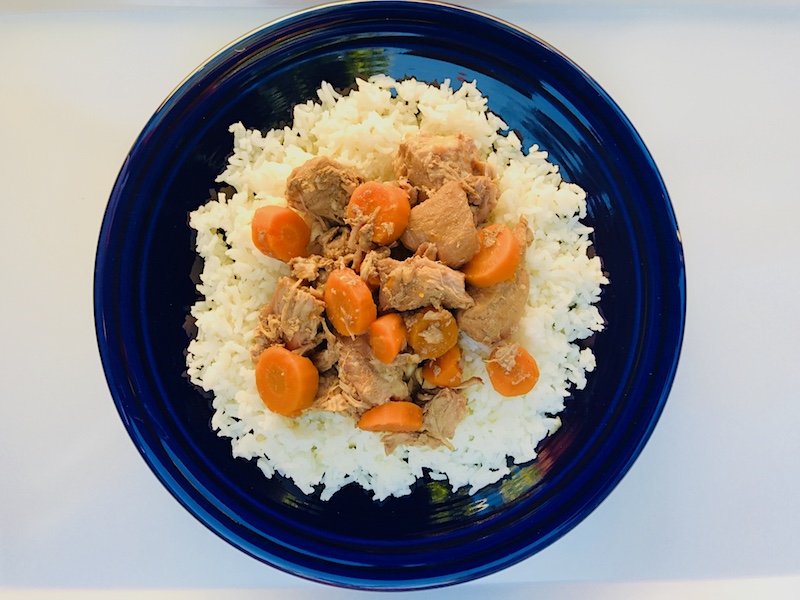 5-Ingredient Slow Cooker Pork Stew cooked and served over white rice on a blow plate.  It's an easy and flavorful! Served over Rice, it's a perfect family dinner.