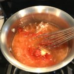 Whisk mixing honey and tomato paste in pot for the Best Sugar Free Ketchup.