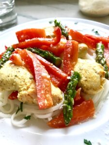 Close up of Mustard Chicken with Red Peppers and Asparagus over rice noodles.