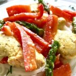 Close Up of Mustard Chicken, Red Peppers, Asparagus over Rice Noodles.