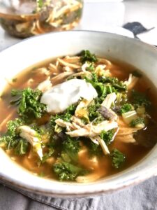 Chicken Tortilla Soup with sour cream on top in bowl on counter