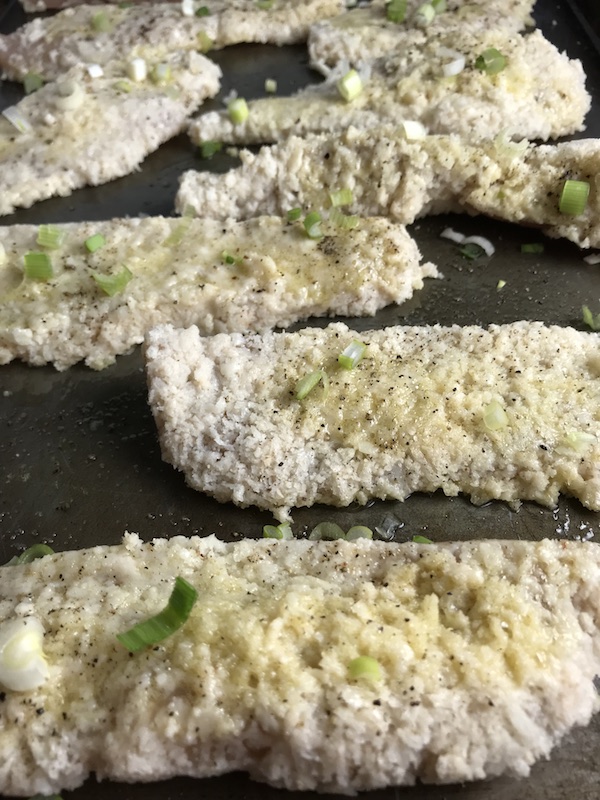 Raw chicken breaded on pan