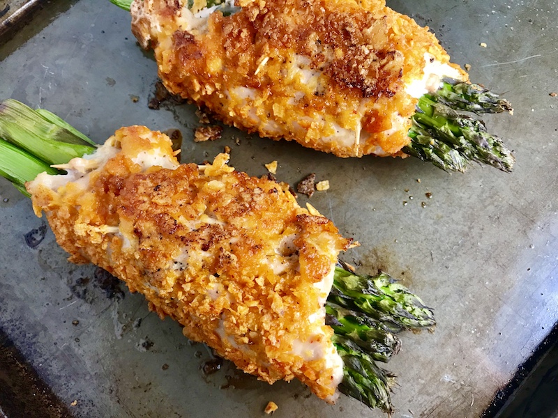 Cheese Tortilla Crusted Chicken Rolls with Asparagus on a sheet pan.