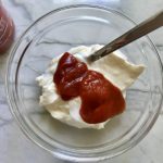 clear bowl on counter with mayonnaise, ketchup, and sriracha sauce