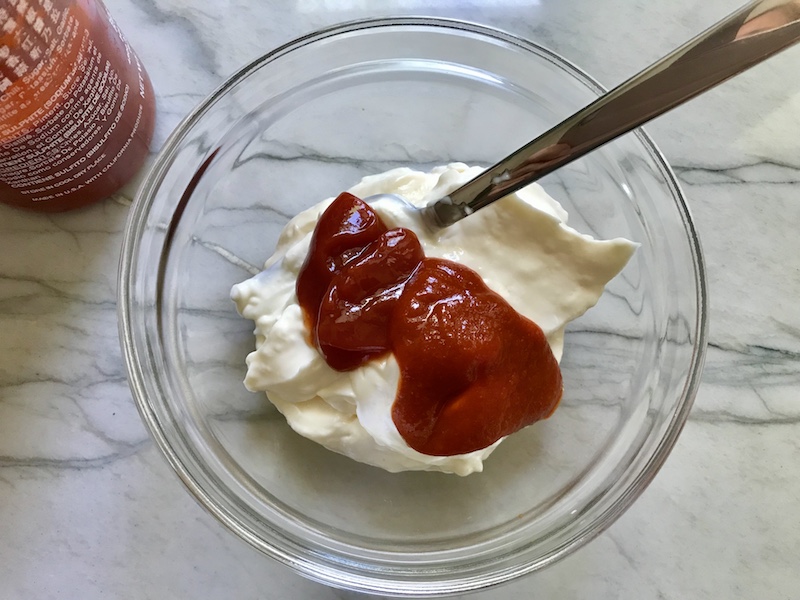 clear bowl on counter with mayonnaise, ketchup, and sriracha sauce