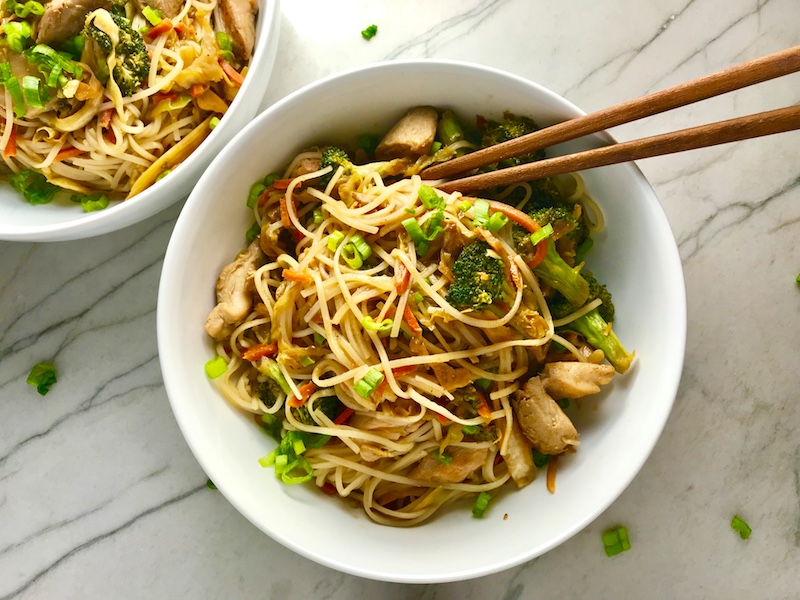 Teriyaki Peanut Sauce Chicken & Broccoli with Noodles in a bowl with chopsticks on the counter