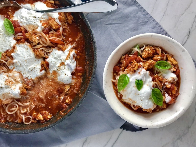 This Skillet Chicken Tomato Sauce with Ricotta is a delicious and simple one pan meal.  Ground chicken is seared until it gets a super browned, flavorful crust.  Then garlic, vegetable broth and tomatoes are added and cooked down into a delightful sauce that really lets the tomato shine with a meaty bite from the chicken.  After pasta is mixed in, creamy Ricotta Cheese is dolloped on and fresh basil added to garnish.  It's perfection! Bellissimo!