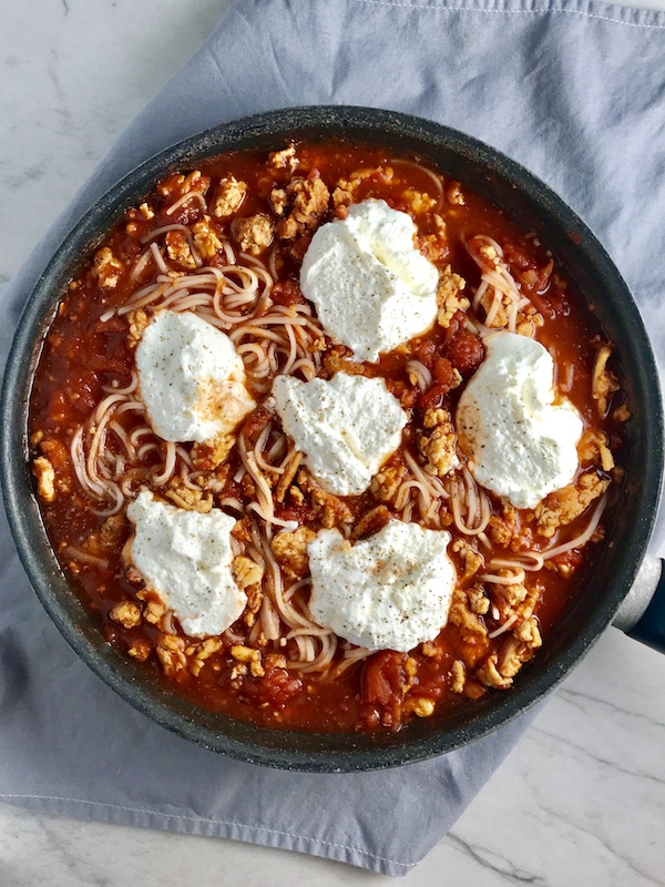 This Skillet Chicken Tomato Sauce with Ricotta is a delicious and simple one pan meal.  Ground chicken is seared until it gets a super browned, flavorful crust.  Then garlic, vegetable broth and tomatoes are added and cooked down into a delightful sauce that really lets the tomato shine with a meaty bite from the chicken.  After pasta is mixed in, creamy Ricotta Cheese is dolloped on and fresh basil added to garnish.  It's perfection! Bellissimo!