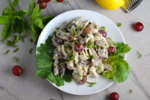 Lemon Basil Chicken Salad with Grapes on a plate on counter with grapes and lemon in background. This recipe is simple, but the taste is anything but simple. It has layers of flavors and textures. You get the hearty texture of the chicken, brightness from the lemon, the fresh and fragrant basil, a slight bite from the onion, and a huge juicy burst of sweetness from the grapes.