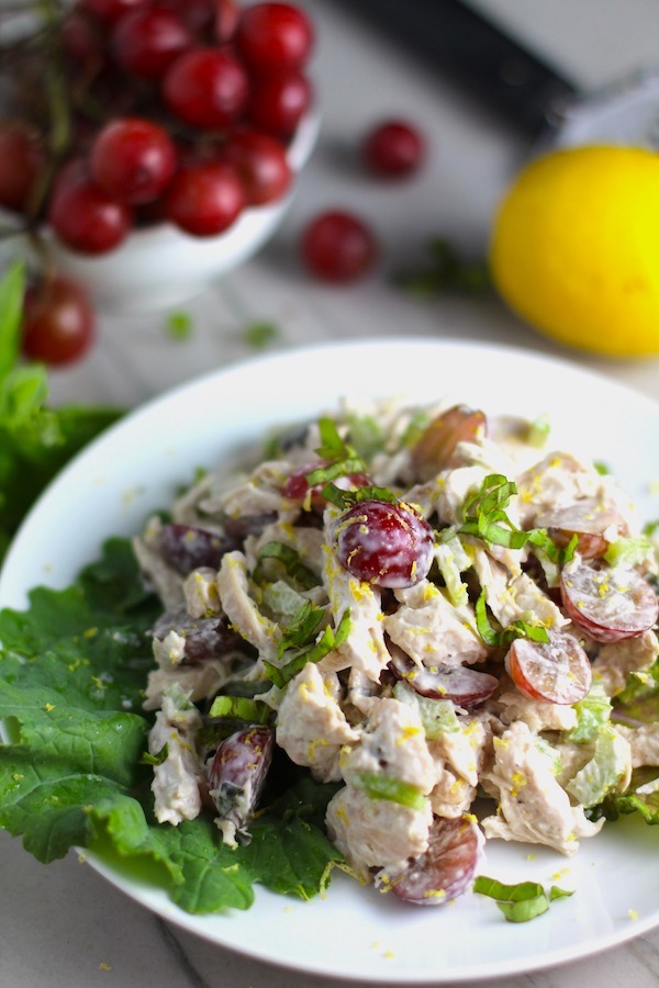 Lemon Basil Chicken Salad with Grapes on a plate on counter with grapes and lemon in background. This recipe is simple, but the taste is anything but simple. It has layers of flavors and textures. You get the hearty texture of the chicken, brightness from the lemon, the fresh and fragrant basil, a slight bite from the onion, and a huge juicy burst of sweetness from the grapes.