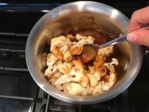 Roasted Cauliflower mixed in sauce in a pot for Korean Rice Bowl with Lentils and Cauliflower recipe, which is da bomb, exploding with flavor! The rice soaks up the sauce, which gives you a nutty, salty flavor from sesame oil and soy sauce, a warm and zesty kick from ginger and garlic, and sweetness from honey to balance it all out. Lentils and cauliflower give a meaty bite.