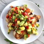 Pineapple Salsa with red pepper, jalapeño, cilantro, scallion, lime, and avocado all over grilled chicken breasts.