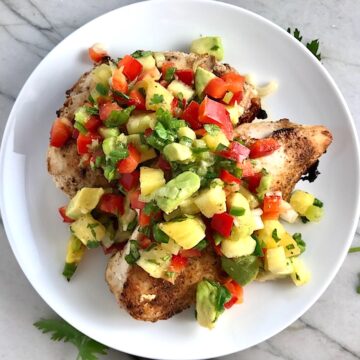 Pineapple Salsa with red pepper, jalapeño, cilantro, scallion, lime, and avocado all over grilled chicken breasts.