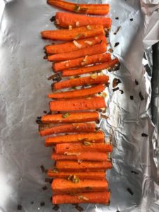 Roasted Carrots on a pan with scallions. Roasted Carrots with smoky cumin and scallions, then topped with Avocado Crema are such a delicious and quick side dish for dinner.  Roasting brings out the natural sugar in the carrots, so they get a sweet caramelization with the salty and smoky flavors. The Avocado crema gives creamy and silky balance. 