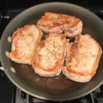 4 Seared pork chops in skillet. Smothered Pork Chop Casserole is a true midwestern comfort dish with layers of vegetables and meaty pork chops smothered in a creamy sauce and cheese.  The pork chops in this delicious casserole are left whole so that you get an entire portion dripping in goodness in one scoop.