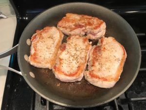 4 Seared pork chops in skillet. Smothered Pork Chop Casserole is a true midwestern comfort dish with layers of vegetables and meaty pork chops smothered in a creamy sauce and cheese.  The pork chops in this delicious casserole are left whole so that you get an entire portion dripping in goodness in one scoop.