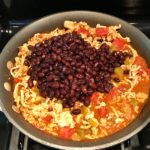 Meat, tomatoes, black beans in skillet. This Taco Casserole has corn tortillas layered with browned ground chicken seasoned with smokey mexican spices, black beans, tomatoes, and cheese, and then more cheese.