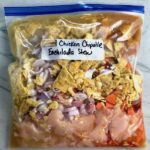 All ingredients in a labeled freezer bag for Chipotle Chicken Enchilada Stew. It is one of my Prepped Freezer Meal recipes and it's creamy, cozy, hearty, cheesy, and slightly spicy. All ingredients freeze raw, thaw, then cook in the slow cooker or in the oven. It's a stew because it's thick and hearty with bites of chicken, carrots, onion, chipotle peppers, cumin, garlic and tortilla chips that melt down to thicken this delicious stew.