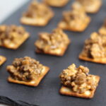 Cooked Hanky Panky on Black Slate Platter. These Hanky Panky Canapes are the BEST Party Appetizers around!  They cheesy, meaty, and absolutely delicious.  Ground Beef is mixed with Homemade Chicken Sausage and then combined with lots of cheese until its a creamy addictive pot of goodness.  Then it is scooped on top of bread, toasts, or crackers