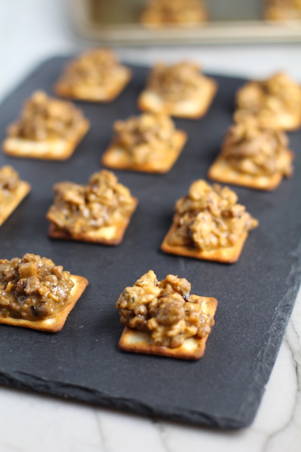 Cooked Hanky Panky on Black Slate Platter. These Hanky Panky Canapes are the BEST Party Appetizers around!  They cheesy, meaty, and absolutely delicious.  Ground Beef is mixed with Homemade Chicken Sausage and then combined with lots of cheese until its a creamy addictive pot of goodness.  Then it is scooped on top of bread, toasts, or crackers