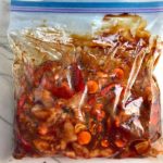 All raw ingredients in freezer bag for Freezer Hoisin Chicken with Red Peppers, Carrots, Onions, Ginger, and Soy sauce is delicious and so easy to make. You get sweet and savory all in one dish and it's perfect for kids because it's sweet, not spicy at all. Just freeze ahead, thaw, then cook on a sheet pan!