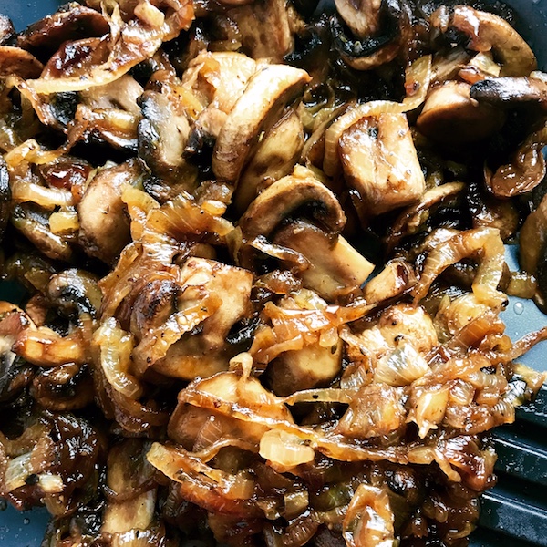 Close up of Caramelized Onions and mushroom slices in skillet for the Caramelized Onions & Mushrooms on Pork Tenderloin recipe.  This is such a flavorful main dish!  The pork tenderloin is moist and juicy and topped with Onions & Mushrooms that are sauteed low and slow with a touch of balsamic to bring out all of the natural sugars and caramelize them to perfection.