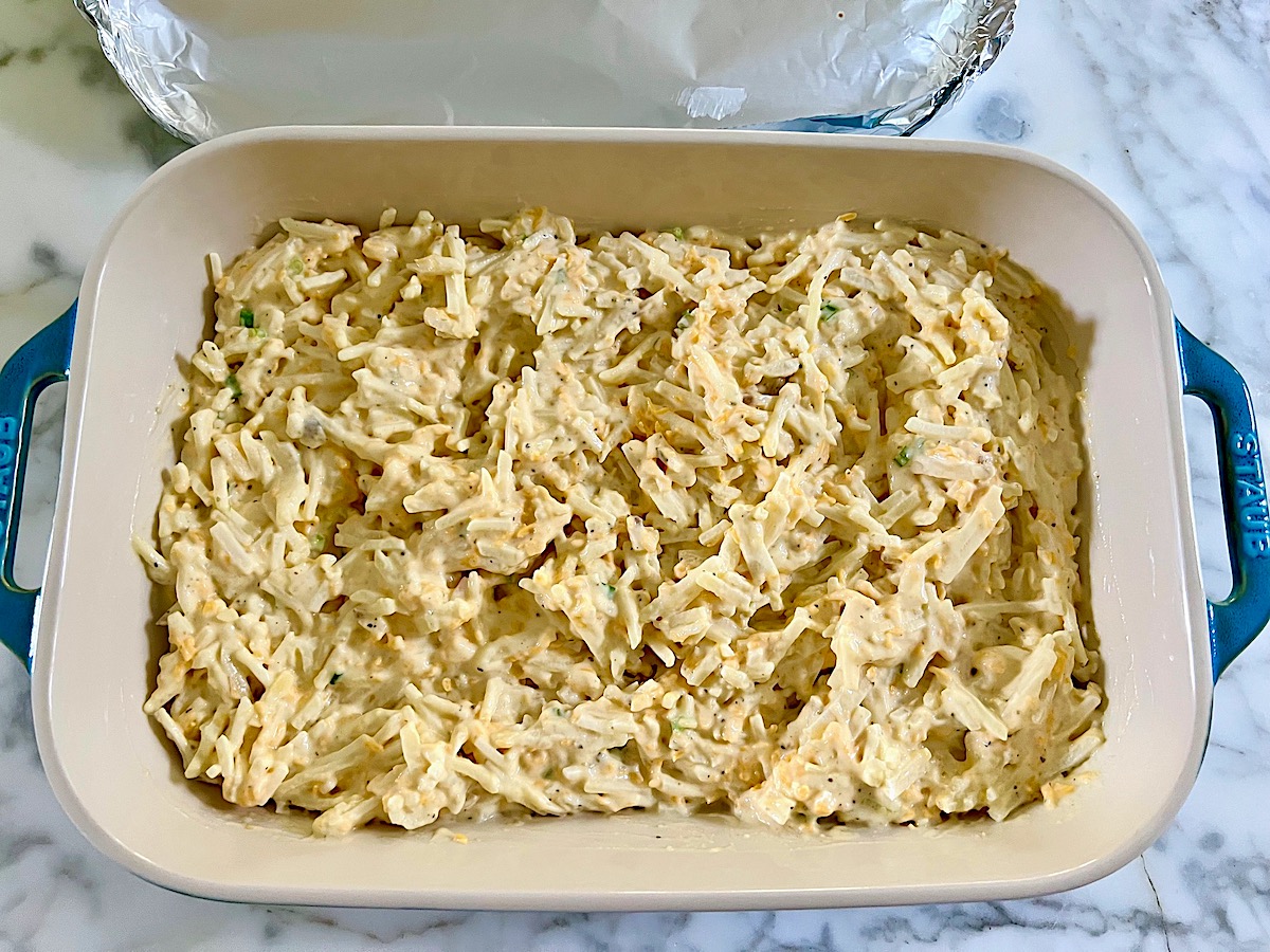 All ingredients mixed together in a casserole dish before being baked for the Hash Brown Casserole without Soup recipe.