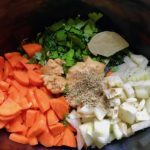 Carrots, onion, and other ingredients in crockpot for the Slow Cooker Beef Stew over Noodles recipe. It's comfort food full of flavor and texture with carrots, onion, garlic, thyme, beef, and more. Now, try pouring that salty, chunky, saucy goodness over noodles...yup, even more amazing! #beefstew #crockpot #slowcooker #easydinners #dinnerrecipes