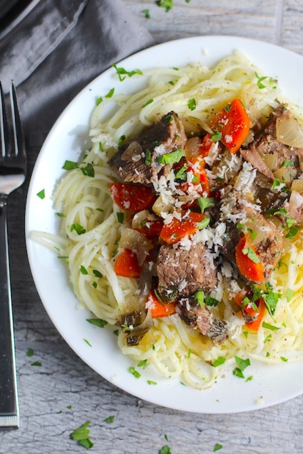 Slow Cooker Beef Stew over Noodles on a plate.  This is downhome comfort food that's full of flavor and texture with carrots, onion, garlic, thyme, beef, and more. Now, try pouring that salty, chunky, saucy goodness over noodles...yup, even more amazing! 