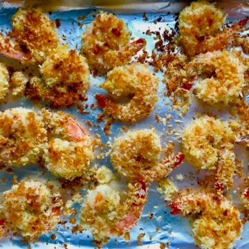 Baked Coconut Shrimp on pan. Crunchy and utterly irresistible, this 30-Minute Baked Coconut Shrimp recipe is one that you have got to try! They are baked, not fried, so they are EASY to cook and HEALTHIER for you too!