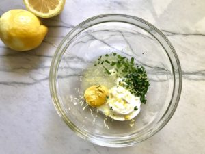 Dressing ingredients in bowl on counter with lemon off to side for Quinoa & Kale Salad with Roasted Chickpeas, Pomegranate, Feta, red pepper, and Creamy Lemon Dressing. #glutenfree #lunch #dinner #healthyrecipes #healthyfood #salads #quinoa #kale