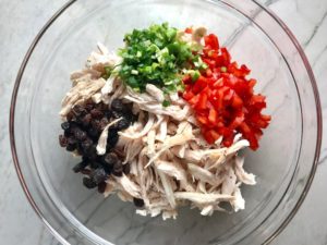 Shredded chicken, red pepper, scallion, and raisins in bowl for Curry Chicken Salad. It has so many fantastic flavors and textures!  The chicken breast is simply roasted and mixed with a creamy sweet and savory curry dressing.  Red pepper gives you a fresh crunch, scallion gives a savory bite, and raisins give a burst of sweet.  #chicken #chickenrecipes #chickensalad #currychicken #mealprep #lunch #healthyrecipes
