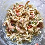 Curry Chicken Salad mixed in bowl. It has so many fantastic flavors and textures!  The chicken breast is simply roasted and mixed with a creamy sweet and savory curry dressing.  Red pepper gives you a fresh crunch, scallion gives a savory bite, and raisins give a burst of sweet.  #chicken #chickenrecipes #chickensalad #currychicken #mealprep #lunch #healthyrecipes