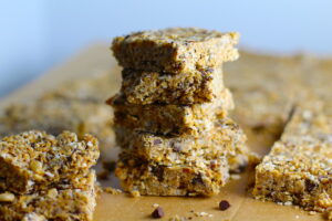 No Bake Energy Bites cut into squares and stacked. These Easy Nut-Free, No-Bake Energy Bites with Chocolate Chips are magnificent!  They are sweet, chewy, crunchy, & healthy.  Only minutes to make & no Baking! Breakfast, snack, or dessert. #energybars #granolabars #snackrecipes #healthyfood #healthyrecipes #healthysnacks #healthybreakfast #healthydessert