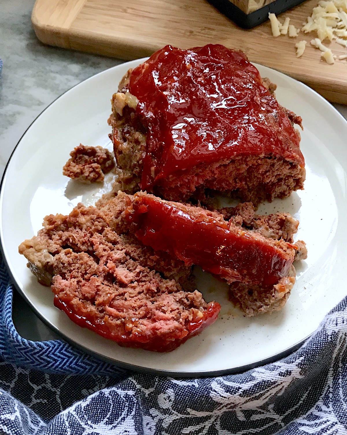 Taco Meatloaf sliced on white plate. This recipe adds a spicy mexican flare with Chipotle Peppers in Adobo Sauce and Cheddar Cheese.  It's incredibly easy, incredibly moist, and incredibly delicious!  A family dinner favorite!
