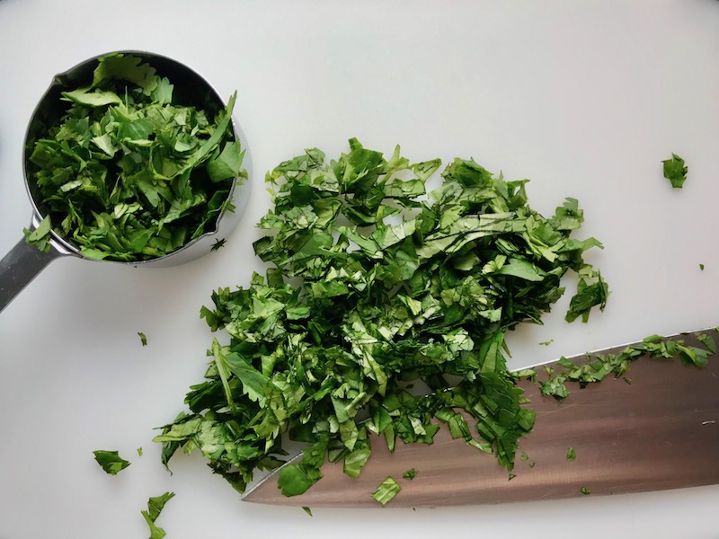 Chopped cilantro on cutting board for Cilantro Lime Quinoa. It's fluffy, nutty, citrusy, salty, and the perfect accompaniment for any protein or vegetable!  With just a few simple ingredients, you can make this fantastic healthier alternative to rice. #quinoa #quinoarecipes #sides #healthyfood