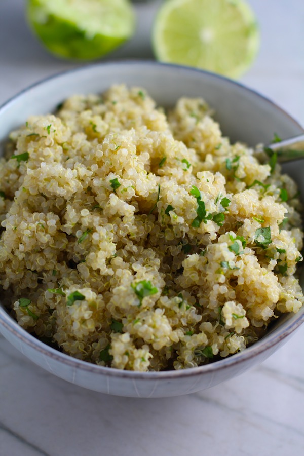 Cilantro Lime Quinoa in a bowl with spoon.  It's fluffy, nutty, citrusy, salty, and the perfect accompaniment for any protein or vegetable!  With just a few simple ingredients, you can make this fantastic healthier alternative to rice. #quinoa #quinoarecipes #sides #healthyfood