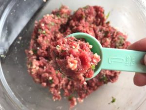 Scooping ground beef mixture out with spoon for Meatballs in Cauliflower Dill Cream Sauce. #meatballs #swedishmeatballs #familydinner #easydinner #dinner #healthydinner