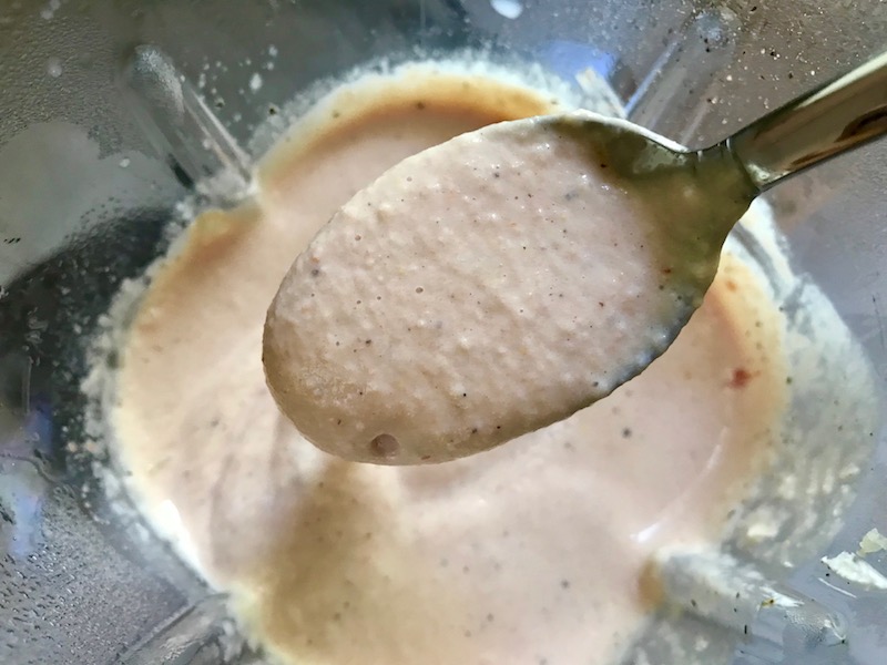 Spoon with Cauliflower cream sauce over blender for Meatballs in Cauliflower Dill Cream Sauce. #meatballs #swedishmeatballs #familydinner #easydinner #dinner #healthydinner