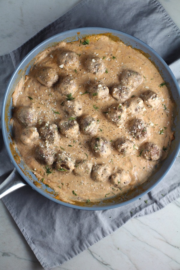 Meatballs in Cauliflower Dill Cream Sauce in a skillet.  The Meatballs are swimming in a beautiful creamy cauliflower sauce flavored with garlic, fresh dill, cream cheese, and a touch of tomato paste.  #meatballs #swedishmeatballs #familydinner #easydinner #dinner #healthydinner