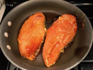 Hungarian Paprika Chicken raw cooking in a skillet. The paprika gives beautiful color and a deep, peppery flavor. #chicken #easychicken #easydinner #dinner #healthydinner