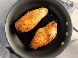 Hungarian Paprika Chicken cooking in a skillet. The paprika gives beautiful color and a deep, peppery flavor. #chicken #easychicken #easydinner #dinner #healthydinner