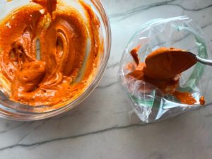 Transferring Paprika Aioli to a baggie for Hungarian Paprika Chicken. The paprika gives beautiful color and a deep, peppery flavor. #chicken #easychicken #easydinner #dinner #healthydinner