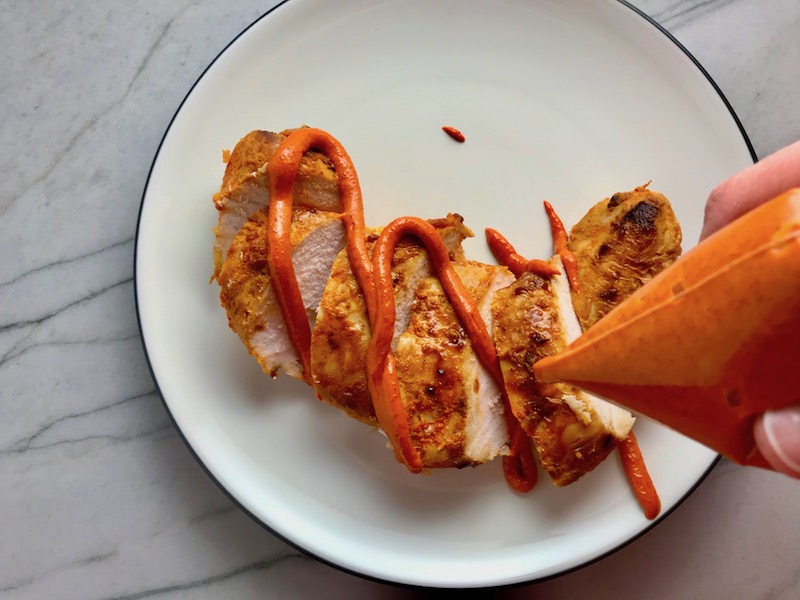 Drizzling Paprika Aioli over Hungarian Paprika Chicken. The paprika gives beautiful color and a deep, peppery flavor. #chicken #easychicken #easydinner #dinner #healthydinner
