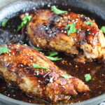Sesame Sweet Chili Chicken cooked in skillet with cilantro leaves. It is slightly sweet, tangy, savory, nutty, with a touch of heat. You can prepare it days ahead, it takes just minutes to prepare, minutes to cook, and everyone will love it!! #chicken #marinades #easydinner #easychicken #chickenrecipes #easysauces #healthydinner #healthyfood #healthyrecipes